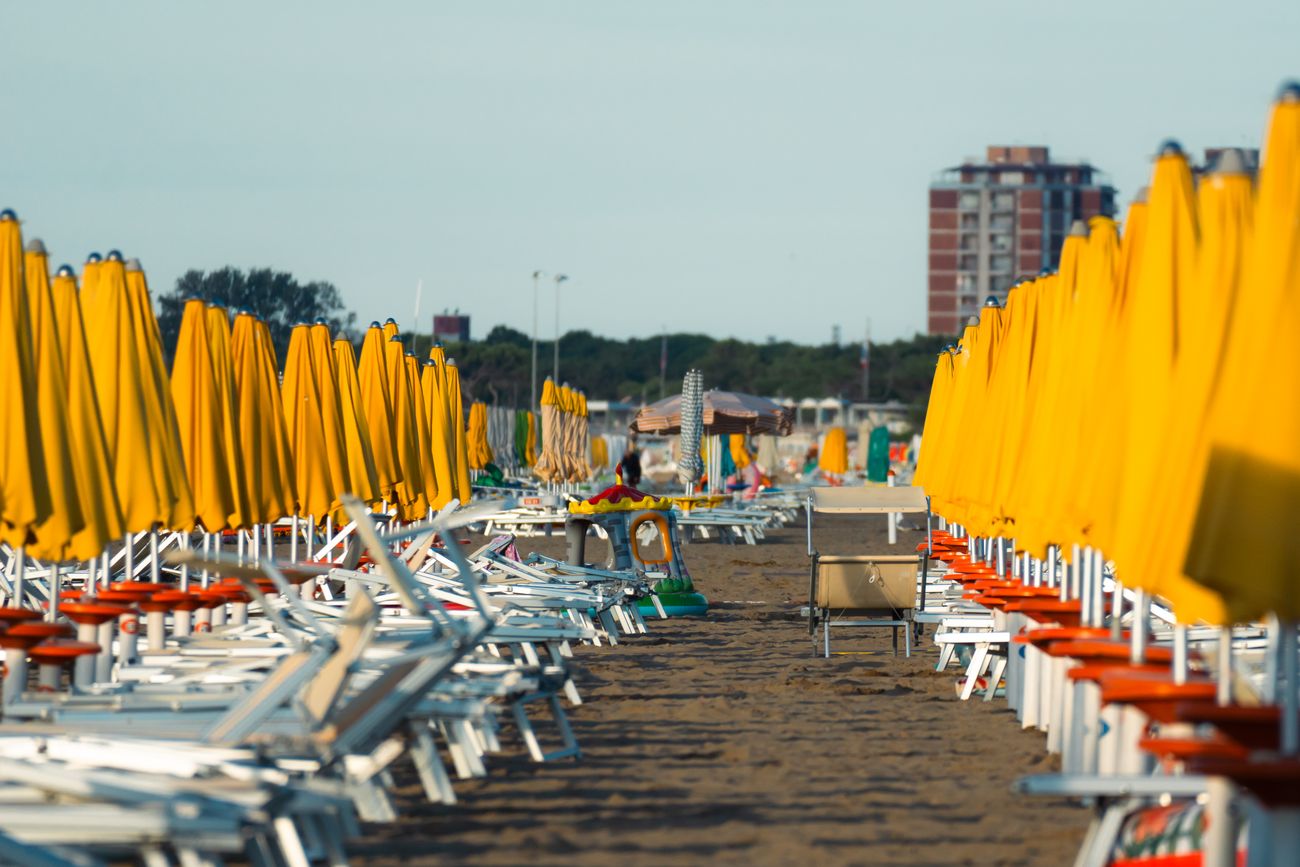 Rij gele parasols en ligbedden op het strand van Lido di Jesolo