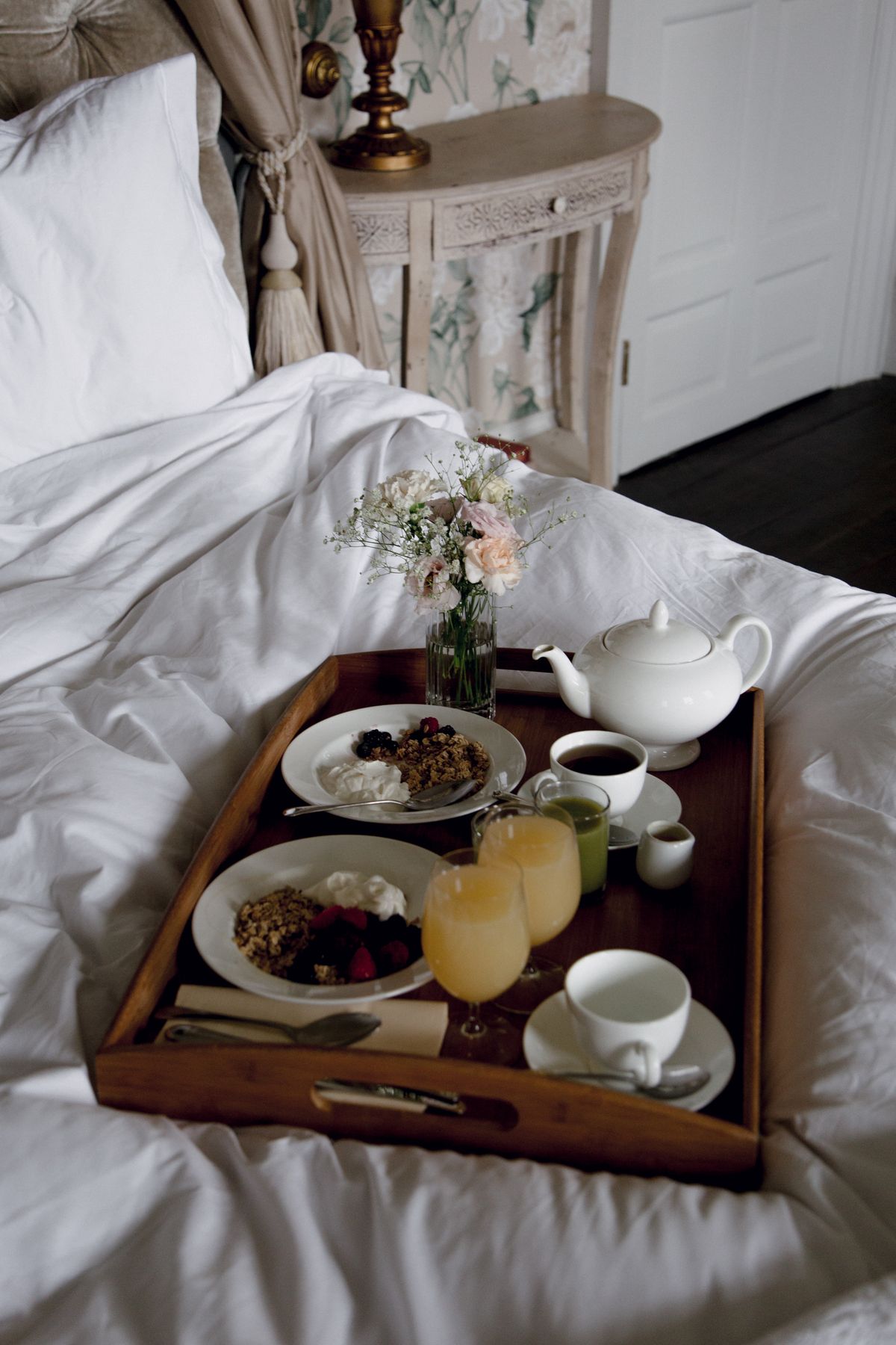 Ontbijt op bed met thee en verse bloemen
